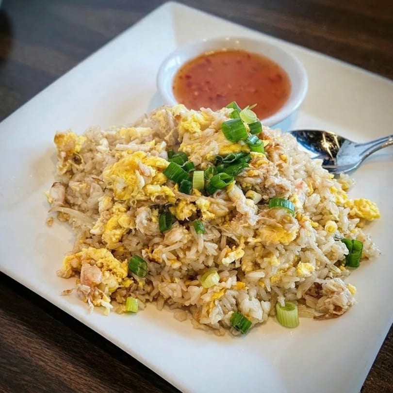 Sri Thai's fried rice with scrambled egg, green onions, and a side of sweet chili sauce.