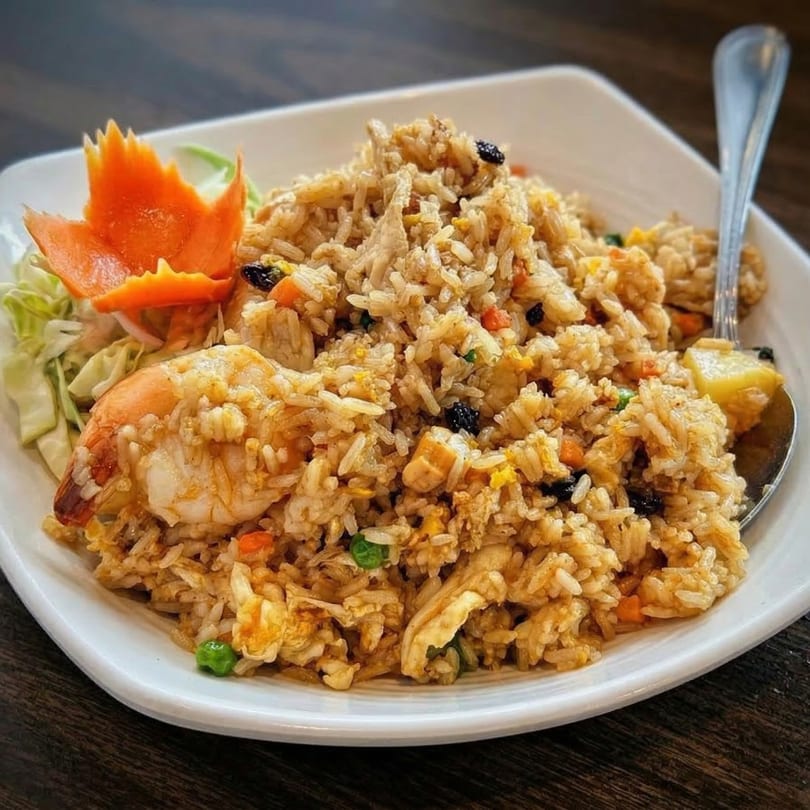Sri Thai's pineapple fried rice with shrimp, chicken, vegetables, and a carved carrot garnish.